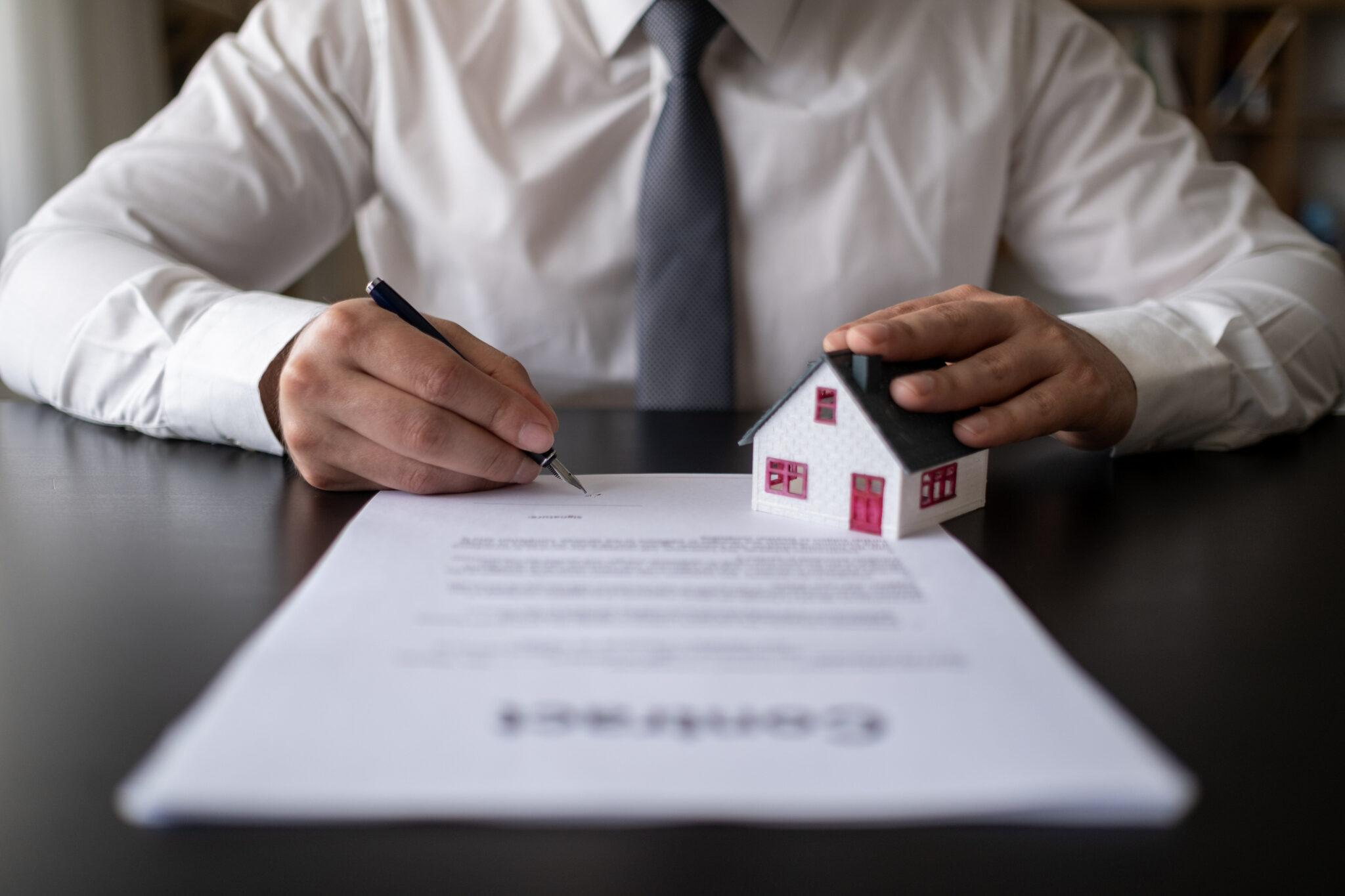 Red Roof House Dealer Sign Contract Concepts Contract Signatures On Documents, Customer Partners, Home Trading, Mortgage, Real Estate, Renting, Buying a House.