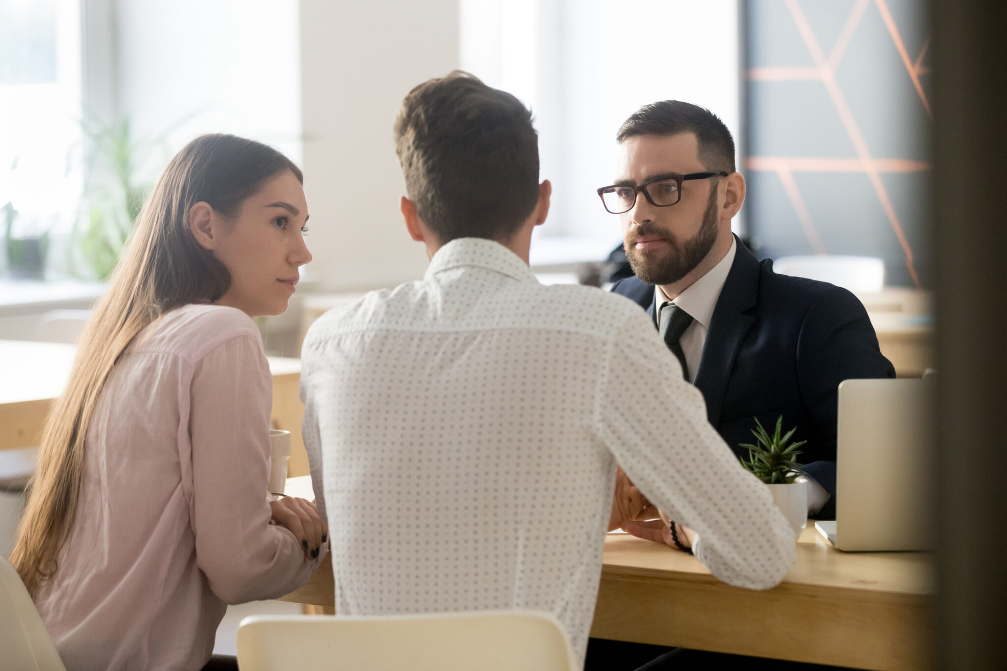 Broker listening to clients during office meeting or consultation